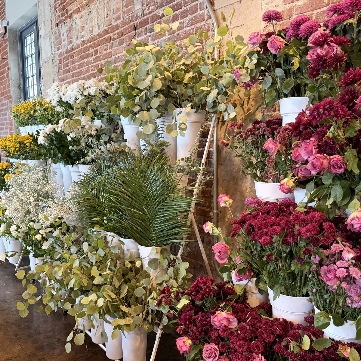 A STEMS bouquet bar: tiered stands of mums, roses and greenery